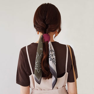 a bohemian paisley silk scarf in plum red, grey and white palette knotted on a woman's ponytail hair