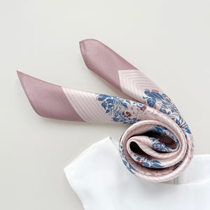 a blush pink silk scarf for women featuring blue and burgundy leafy print, paired with a white sleeveless dress