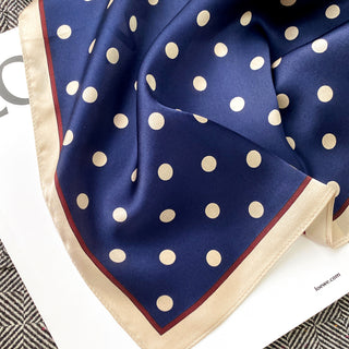 a navy blue small silk scarf/neckerchief with polka dot pattern