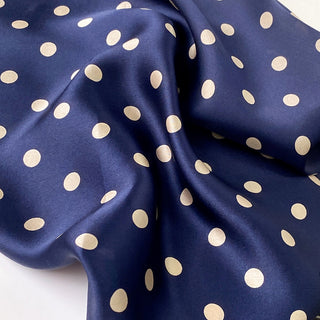 a navy blue small silk scarf/neckerchief with polka dot pattern