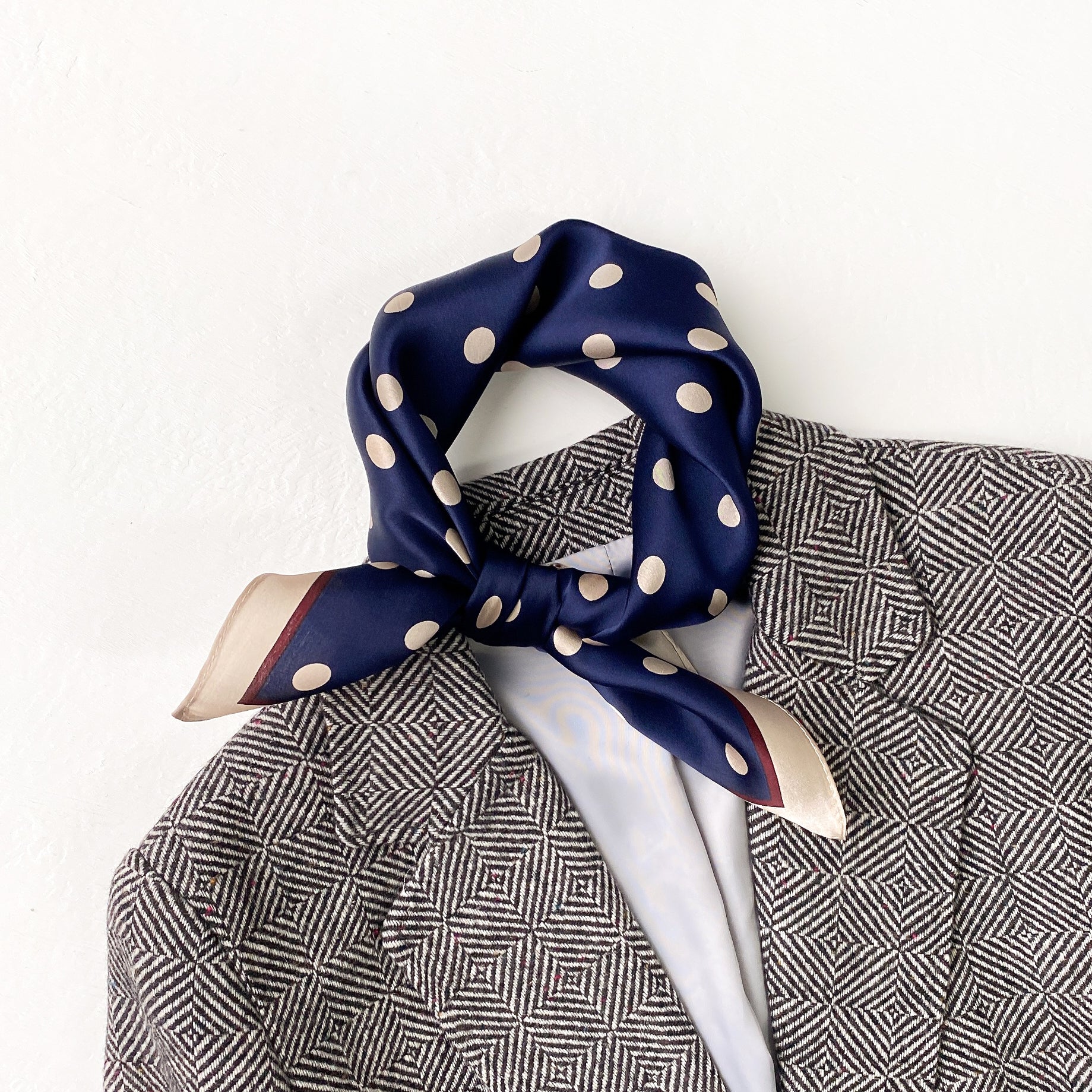 a navy blue small silk scarf/neckerchief with polka dot pattern