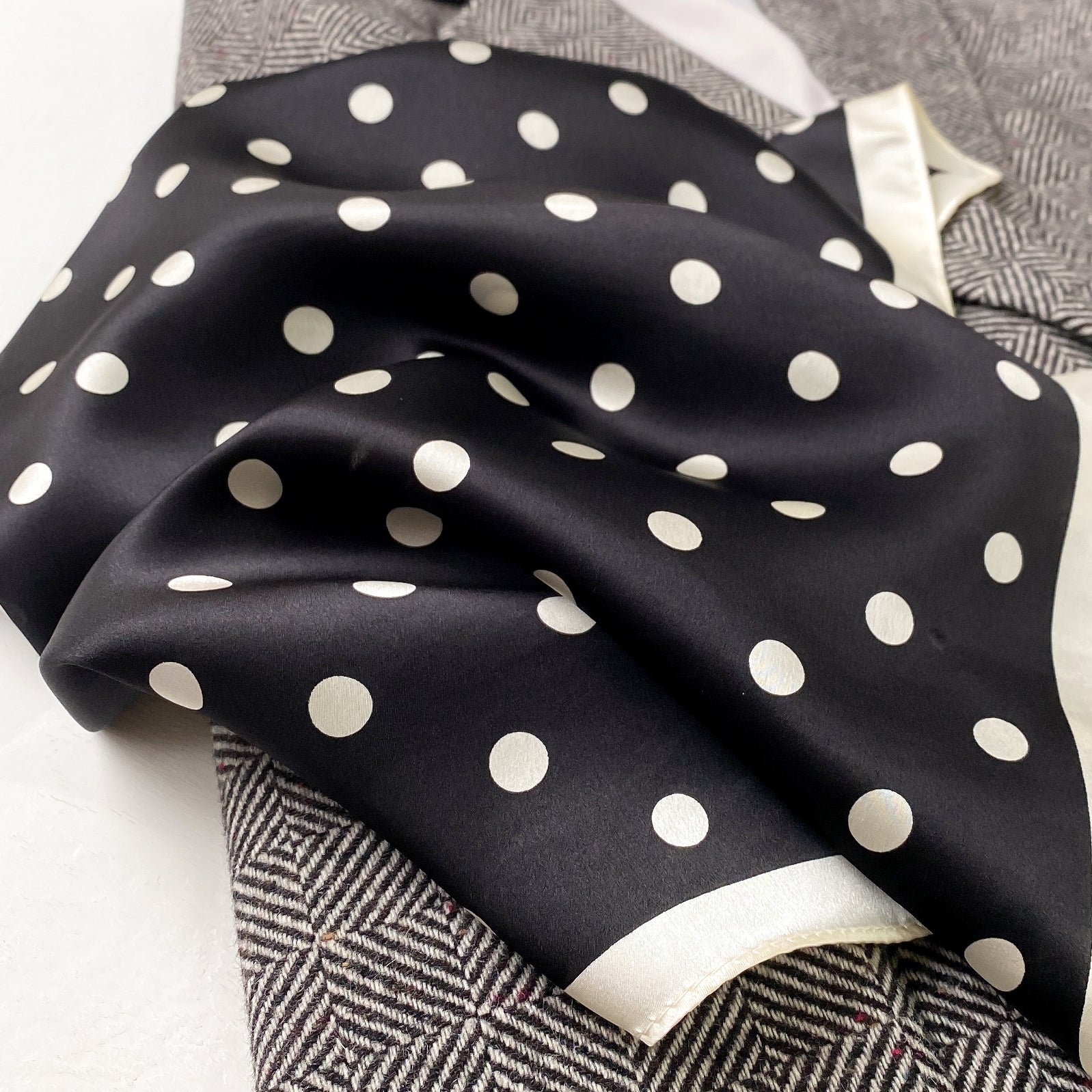 a black small silk scarf/neckerchief with polka dot pattern