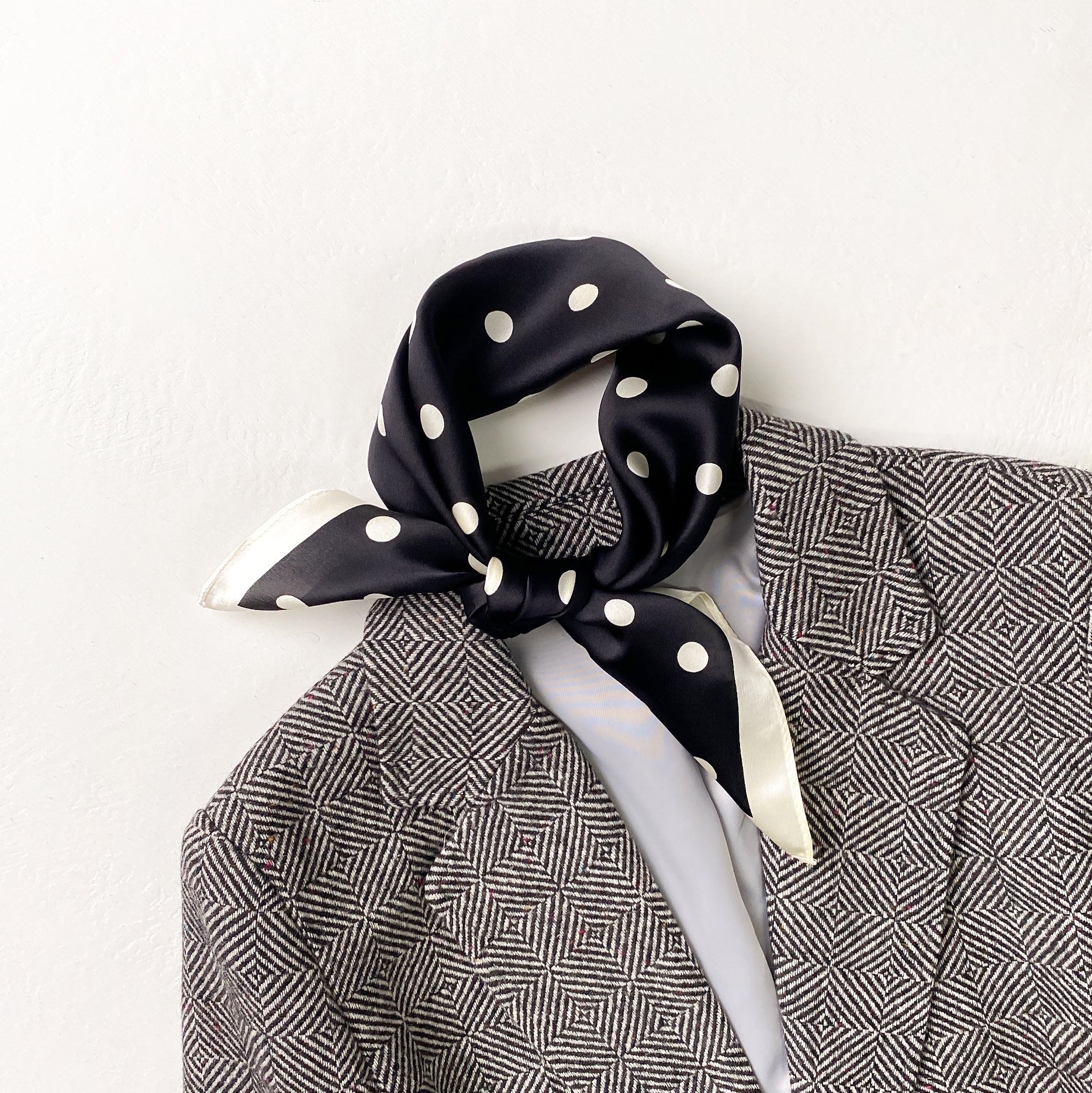 a black small silk scarf/neckerchief with polka dot pattern