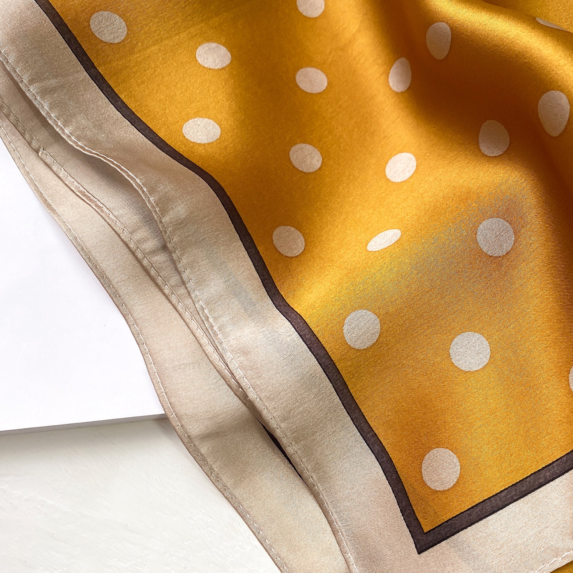 a mustard yellow small silk scarf/neckerchief with polka dot pattern  Edit alt text