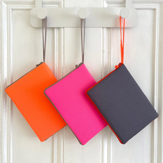 recycled kindle case in three different colors: neon orange, neon pink and dark grey