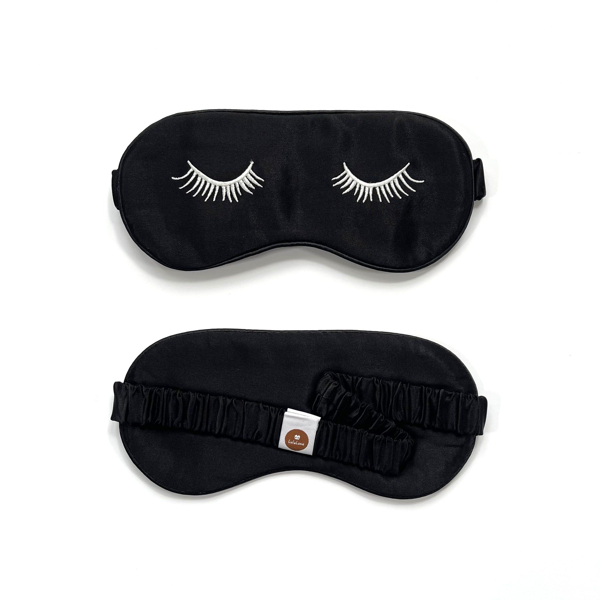 a black silk eye mask featuring white eyelashes embroidery and elastic strap