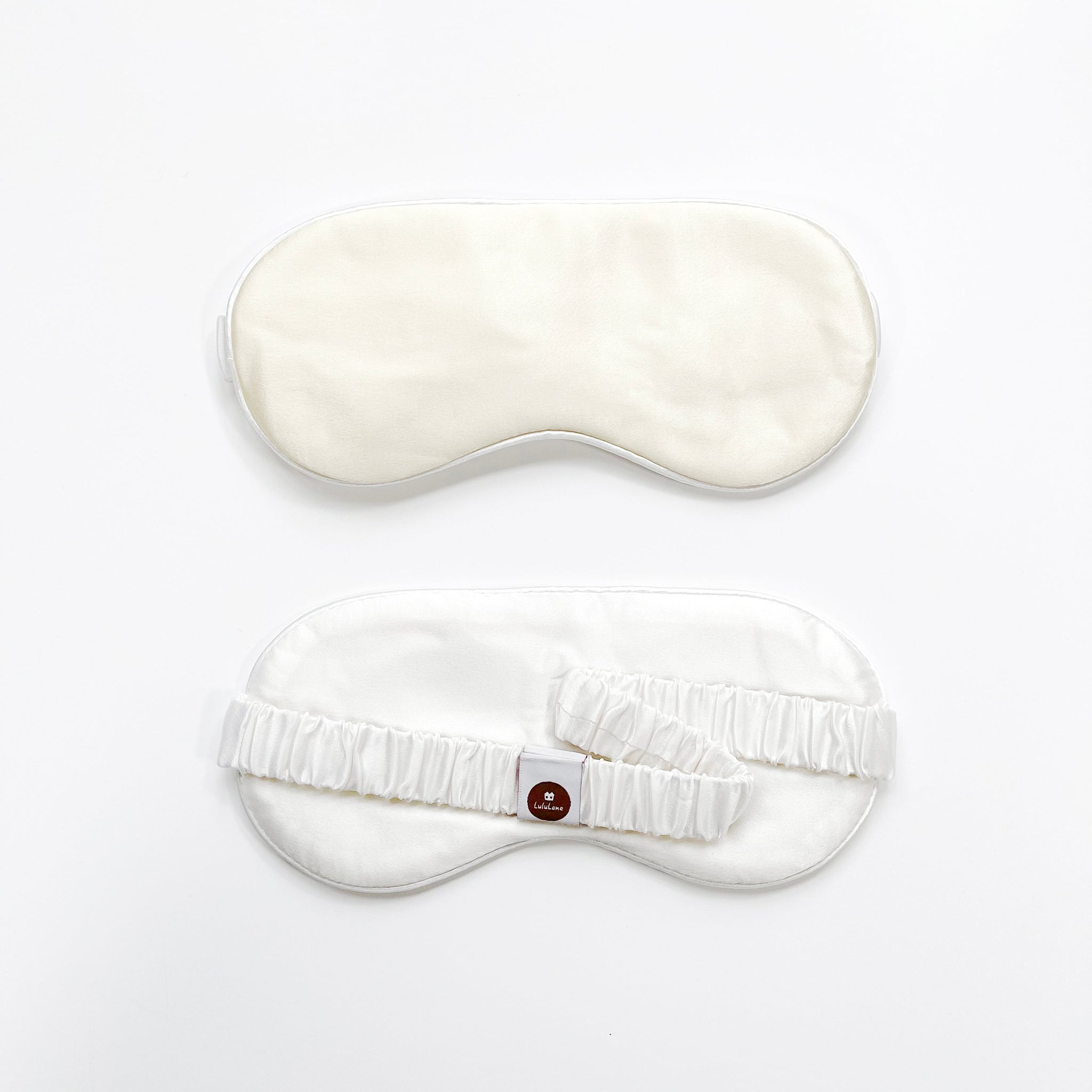 a creamy white silk eye mask with off white back side and elastic strap